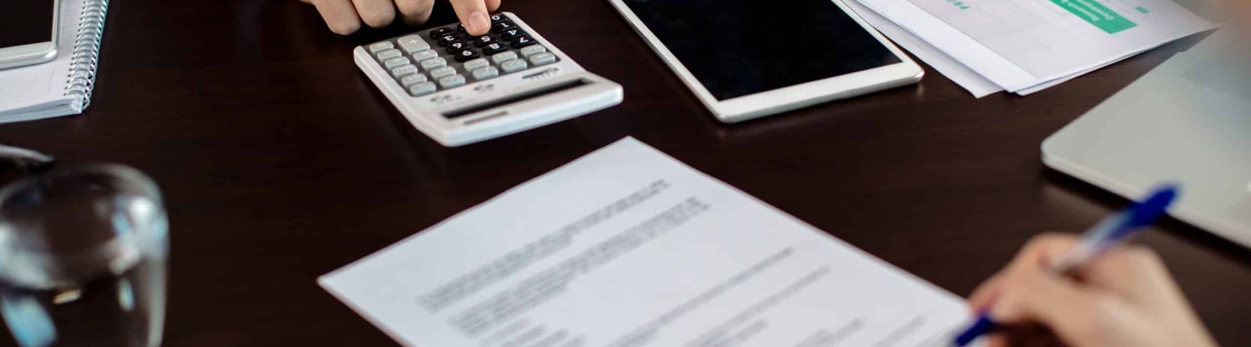 Close-up of insurance agent calculating costs an agreement while having a meeting with a client.