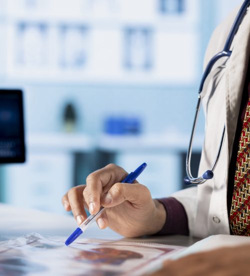 General practitioner consulting patient and reviewing x ray test results, utilizing technology for accurate analysis and patient care management in a medical environment. Healthcare provider.